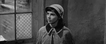 Movie still from “The Diary of Anne Frank” (1959), directed by George Stevens – A young woman wearing a hat and a coat; Close Up shot, High angle