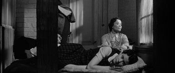 Movie still from “The Diary of Anne Frank” (1959), directed by George Stevens – A woman sitting on a bed next to another woman; Medium shot, High angle