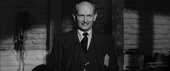 Movie still from “The Diary of Anne Frank” (1959), directed by George Stevens – An older man wearing a suit and tie; Close Up shot, Low angle