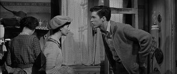 Movie still from “The Diary of Anne Frank” (1959), directed by George Stevens – A young boy and a young man talking to each other; Medium shot, Low angle