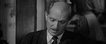 Movie still from “The Diary of Anne Frank” (1959), directed by George Stevens – An older man in a suit and tie looking to his left; Close Up shot, Over the shoulder angle