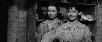 Movie still from “The Diary of Anne Frank” (1959), directed by George Stevens – Two young women standing next to each other in front of a shelf; Close Up shot, Low angle