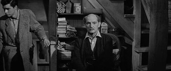 Movie still from “The Diary of Anne Frank” (1959), directed by George Stevens – An older man sitting in front of a book shelf; Medium shot, High angle
