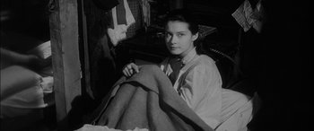 Movie still from “The Diary of Anne Frank” (1959), directed by George Stevens – Black and white photograph of a woman holding a blanket; Medium shot, High angle