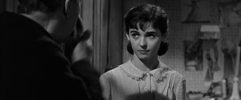 Movie still from “The Diary of Anne Frank” (1959), directed by George Stevens – A woman in a white shirt is standing in front of a mirror; Close Up shot, Over the shoulder angle
