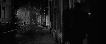 Movie still from “The Diary of Anne Frank” (1959), directed by George Stevens – A black - and - white photo of an alley at night; Wide shot, Over the shoulder angle