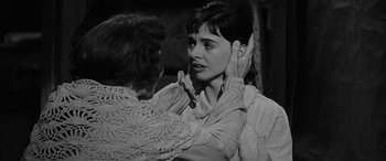 Movie still from “The Diary of Anne Frank” (1959), directed by George Stevens – A woman putting a face mask on another woman's face; Close Up shot, Over the shoulder angle