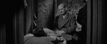 Movie still from “The Diary of Anne Frank” (1959), directed by George Stevens – An older man sitting in front of a young man; Medium shot, Over the shoulder angle