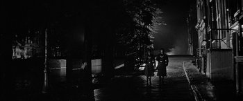 Movie still from “The Diary of Anne Frank” (1959), directed by George Stevens – A couple of people standing next to each other on a street; Wide shot, Low angle