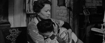 Movie still from “The Diary of Anne Frank” (1959), directed by George Stevens – An older woman holding a young child in her arms; Close Up shot, Low angle