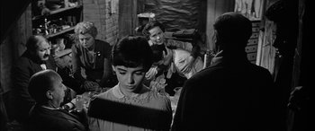Movie still from “The Diary of Anne Frank” (1959), directed by George Stevens – A group of people standing in a room; Medium shot, Over the shoulder angle