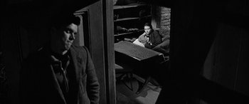 Movie still from “The Diary of Anne Frank” (1959), directed by George Stevens – A man sitting at a table in front of another man; Medium shot, Over the shoulder angle