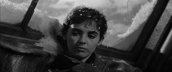 Movie still from “The Diary of Anne Frank” (1959), directed by George Stevens – A black - and - white photo of a young woman with flowers in her hair; Close Up shot, Low angle