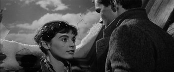 Movie still from “The Diary of Anne Frank” (1959), directed by George Stevens – A man and a woman standing next to each other under an umbrella; Close Up shot, Low angle