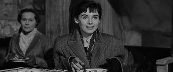 Movie still from “The Diary of Anne Frank” (1959), directed by George Stevens – A woman sitting at a table with a plate in front of her; Close Up shot, High angle