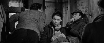 Movie still from “The Diary of Anne Frank” (1959), directed by George Stevens – A black and white photo of a woman sitting on a bench; Medium shot, Over the shoulder angle