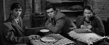 Movie still from “The Diary of Anne Frank” (1959), directed by George Stevens – A man sitting at a table with a plate on it; Medium shot, High angle