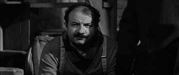 Movie still from “The Diary of Anne Frank” (1959), directed by George Stevens – An older man with a mustache wearing a neck tie; Close Up shot, Over the shoulder angle