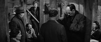 Movie still from “The Diary of Anne Frank” (1959), directed by George Stevens – A black and white photo of a group of people; Medium shot, Over the shoulder angle