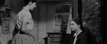 Movie still from “The Diary of Anne Frank” (1959), directed by George Stevens – A man and a woman are standing in a room; Medium shot, Over the shoulder angle