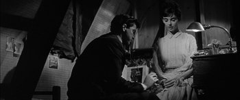 Movie still from “The Diary of Anne Frank” (1959), directed by George Stevens – A man and a woman looking at a cell phone; Medium shot, High angle