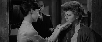 Movie still from “The Diary of Anne Frank” (1959), directed by George Stevens – A woman touching the face of another woman in front of another man; Close Up shot, Over the shoulder angle