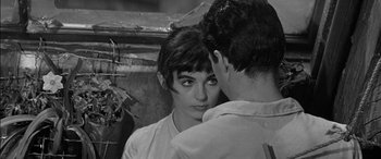 Movie still from “The Diary of Anne Frank” (1959), directed by George Stevens – A young woman looking at a young man in front of a window; Close Up shot, High angle