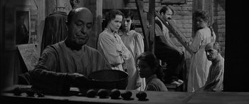 Movie still from “The Diary of Anne Frank” (1959), directed by George Stevens – A black and white photo of a group of people; Medium shot, Low angle