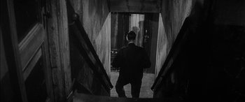 Movie still from “The Diary of Anne Frank” (1959), directed by George Stevens – A man walking down a set of stairs; Medium shot, High angle