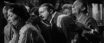 Movie still from “The Diary of Anne Frank” (1959), directed by George Stevens – An old photo of a group of people gathered together; Close Up shot, High angle