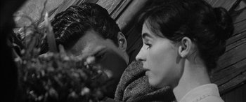 Movie still from “The Diary of Anne Frank” (1959), directed by George Stevens – A man and a woman sitting close together; Close Up shot, High angle