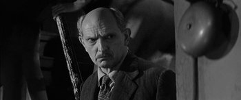 Movie still from “The Diary of Anne Frank” (1959), directed by George Stevens – An older man with a bald head and a mustache; Close Up shot, High angle