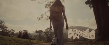 Movie still from “The Diary of a Teenage Girl” (2015), directed by Marielle Heller – A woman walking down a road with a backpack; Wide shot, Low angle