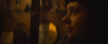 Movie still from “The Diary of a Teenage Girl” (2015), directed by Marielle Heller – A woman's face in a dark room; Close Up shot, Over the shoulder angle