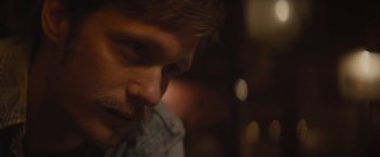 Movie still from “The Diary of a Teenage Girl” (2015), directed by Marielle Heller – A man's face in a dimly - lit room; Close Up shot, Over the shoulder angle
