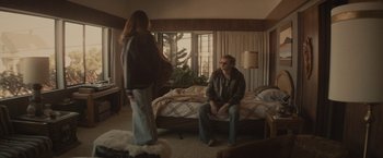 Movie still from “The Diary of a Teenage Girl” (2015), directed by Marielle Heller – A man and a woman sitting on a bed in front of a window; Wide shot, High angle