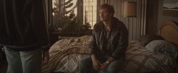 Movie still from “The Diary of a Teenage Girl” (2015), directed by Marielle Heller – A man sitting on a bed in front of a window; Medium shot, Over the shoulder angle