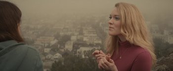 Movie still from “The Diary of a Teenage Girl” (2015), directed by Marielle Heller – A woman eating a hot dog on top of a hill; Close Up shot, High angle