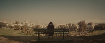Movie still from “The Diary of a Teenage Girl” (2015), directed by Marielle Heller – A person sitting on a bench looking out over a city; Extreme Wide shot, High angle