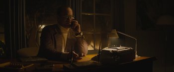 Movie still from “The Diary of a Teenage Girl” (2015), directed by Marielle Heller – A man sitting at a desk talking on the phone; Medium shot, Low angle