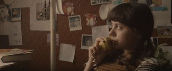 Movie still from “The Diary of a Teenage Girl” (2015), directed by Marielle Heller – A woman holding a banana while talking on the phone; Close Up shot, High angle