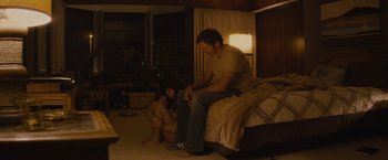 Movie still from “The Diary of a Teenage Girl” (2015), directed by Marielle Heller – A man sitting on top of a bed next to a woman; Wide shot, High angle