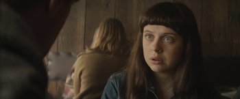 Movie still from “The Diary of a Teenage Girl” (2015), directed by Marielle Heller – A woman with bangs looking at the camera with another woman in the background; Close Up shot, Over the shoulder angle