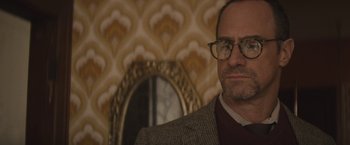 Movie still from “The Diary of a Teenage Girl” (2015), directed by Marielle Heller – A person wearing glasses and a suit; Close Up shot, Over the shoulder angle