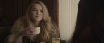 Movie still from “The Diary of a Teenage Girl” (2015), directed by Marielle Heller – A woman sitting in front of a mirror holding a cup; Close Up shot, Over the shoulder angle