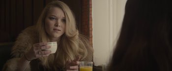 Movie still from “The Diary of a Teenage Girl” (2015), directed by Marielle Heller – A woman sitting in front of a mirror holding a glass of orange juice; Close Up shot, Over the shoulder angle