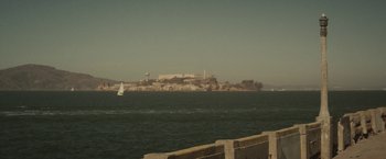 Movie still from “The Diary of a Teenage Girl” (2015), directed by Marielle Heller – A view of a large body of water with a castle on top of it; Extreme Wide shot, High angle