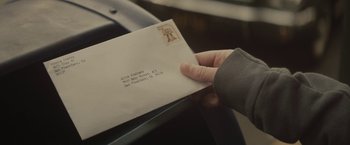 Movie still from “The Diary of a Teenage Girl” (2015), directed by Marielle Heller – A person holding an envelope with a stamp on it; Extreme Close Up shot, Overhead angle