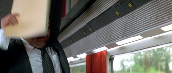 Movie still from “Le Dîner de Cons” (1998), directed by Francis Veber – A man sitting on a train looking out the window; Medium shot, Low angle