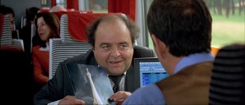 Movie still from “Le Dîner de Cons” (1998), directed by Francis Veber – A man sitting in front of a laptop computer; Close Up shot, Over the shoulder angle